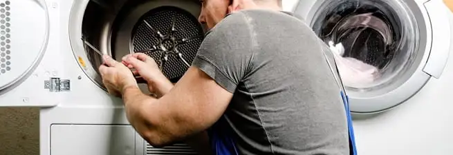 Dryer repair technician fixing a clothes dryer drum in Yonkers, NY