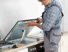 Appliance repair technician installing a built-in cooktop in Yonkers, NY