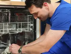 Dishwasher repair technician inspecting and servicing an open dishwasher in Yonkers, NY