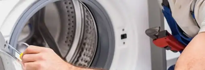 Appliance technician repairing a clothes dryer drum and internal parts in Yonkers, NY