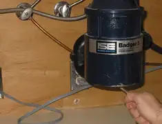 Garbage disposal repair technician tightening the mounting ring under a sink in Yonkers, NY