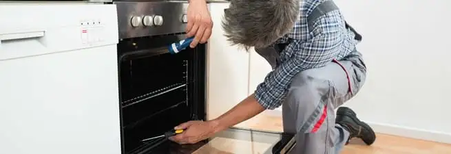 Oven repair technician inspecting and servicing an electric oven in Yonkers, NY