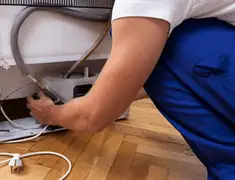 Appliance repair technician fixing refrigerator water line and connections in Yonkers, NY
