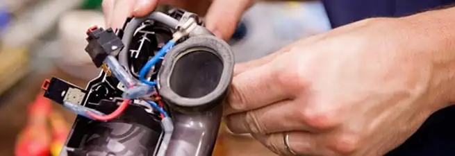 Vacuum repair technician reconnecting wiring and components in Yonkers, NY
