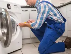 Washing machine repair technician servicing a front-load washer in Yonkers, NY