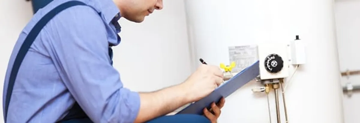 Water heater repair technician inspecting the unit and recording service notes in Yonkers, NY