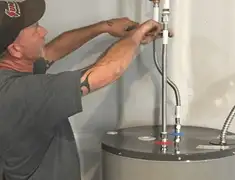 Water heater repair technician tightening supply line connections in Yonkers, NY